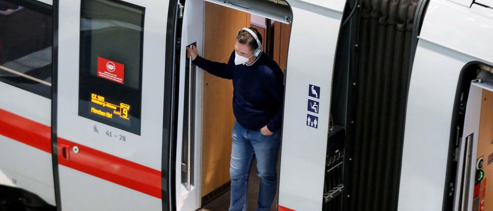 Ein Fahrgast mit FFP2 Maske steht am Berliner Bahnhof.