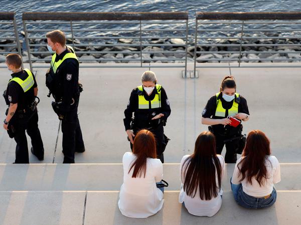 Mitarbeiterinnen des Ordnungsamts kontrollieren in Köln drei Frauen.