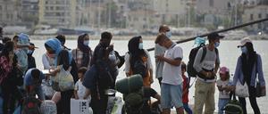 Migranten stehen Schlange, um eine Fähre von der Insel Lesbos zum griechischen Festland zu besteigen. 