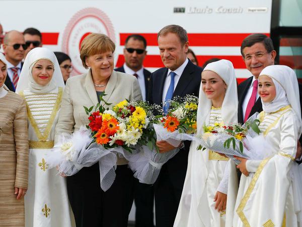 Angela Merkel, Donald Tusk und der türkische Premier Ahmet Davutoglu im Flüchtlingslager Gaziantep in der Türkei.  