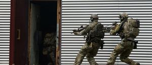 Soldaten des Kommandos Spezialkräfte (KSK) stürmen auf dem Kasernengelände während einer Übung in eine Tür. 