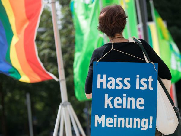 Eine Aktivistin der Nichtregierungsorganisation Campact steht mit einem Plakat mit der Aufschrift «Hass ist keine Meinung» am Eingang zum Landesparteitag von Bündnis 90/Die Grünen.