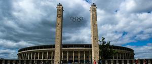 ARCHIV - Menschen gehen am 23.06.2014 in Berlin am Olympiastadion vorbei. Der DOSB gibt am 16.03. eine Empfehlung für die deutsche Bewerberstadt für die Olympischen Spiele 2024/2028 ab. Foto: Paul Zinken/dpa +++(c) dpa - Bildfunk+++ | Verwendung weltweit