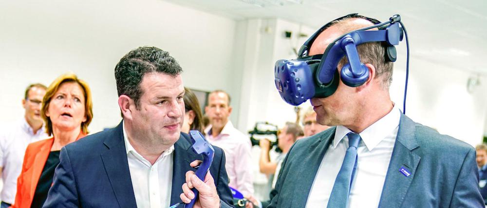 Arbeitsminister Hubertus Heil (SPD) lässt sich bei BASF von Vorstandschef Martin Brudermüller eine Virtual-Realität-Brille erklären