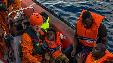 Mitglieder der deutschen Organisation Sea-Eye bringen Migranten zum Rettungsschiff "Alan Kurdi".