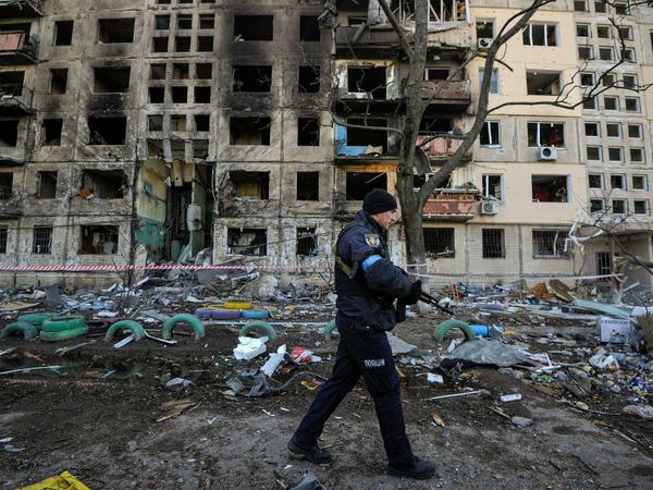 Wachdienst an Ruinen. Ein Polizist patrouilliert in einem schwer getroffenen Wohnviertel von Kiew. Im Einsatz sind auch Zivilisten, die sich bei der Territorialen Verteidigung gemeldet haben. 
