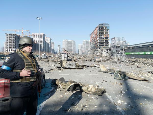 Zerstörung ohne Ende. Kiew wird immer wieder von den russischen Invasoren beschossen. Im Bild die Trümmer eines Einkaufszentrums. Ein Mitglied der Territorialen Verteidigung steht im Chaos Wache.