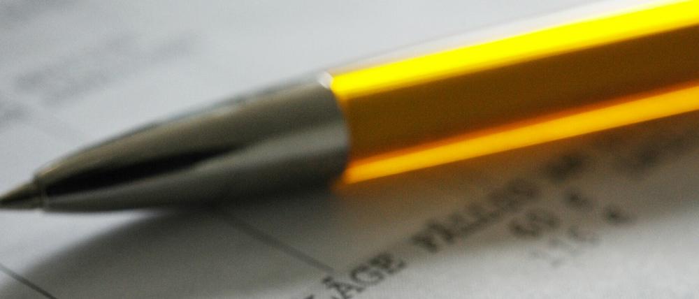 Ein Stift liegt auf einem Abwassergebührenbescheid.