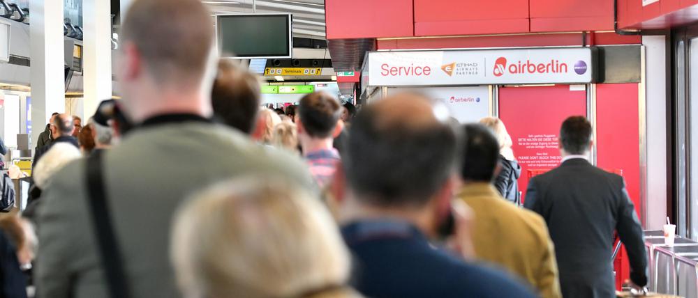 Passagiere warten an einem Serviceschalter von Air Berlin auf dem Flughafen Tegel in Berlin. Wegen Krankmeldungen zahlreicher Piloten hat Air Berlin am Dienstag Dutzende Flüge abgesagt.