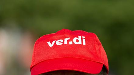 Ein Bankangestellter trägt beim Warnstreik eine Mütze mit dem Verdi Logo. 