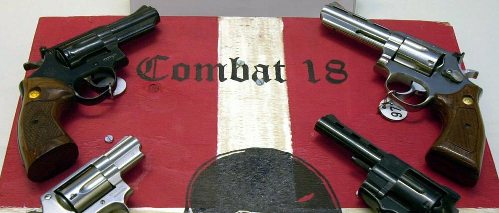 Sichergestellte Waffen und ein Schild der kriminellen Neonazi-Gruppe "Combat 18" (Archivbild).