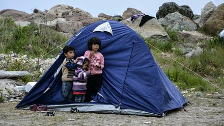Kinder stehen vor einem Zelt im Dorf Petra auf der nordöstlichen Ägäisinsel Lesbos.