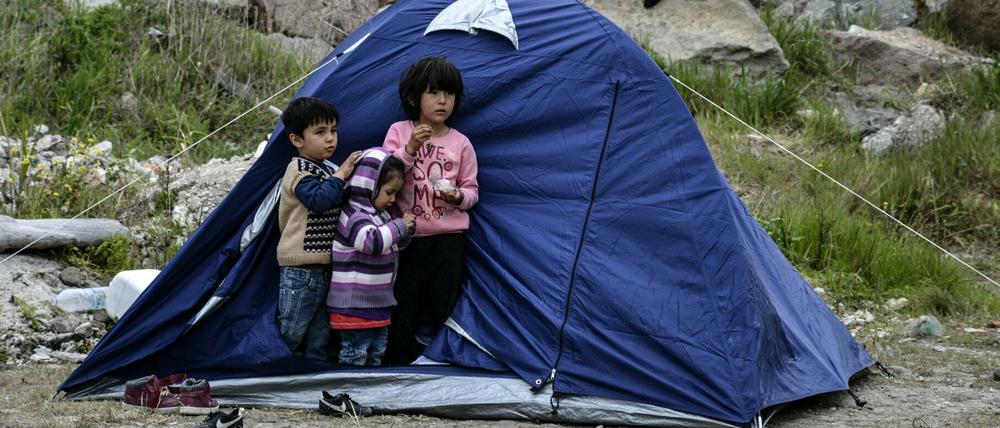 Kinder stehen vor einem Zelt im Dorf Petra auf der nordöstlichen Ägäisinsel Lesbos.
