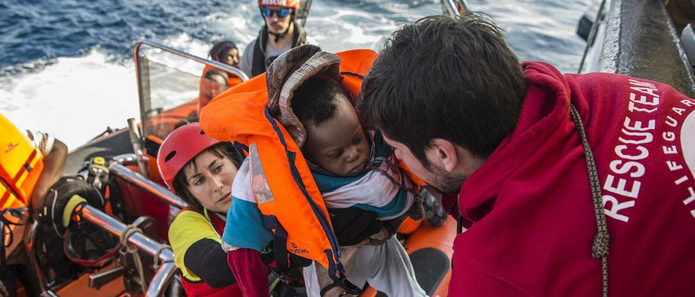 Ein Baby wird in ein Rettungsboot gebracht, nachdem eine spanische Nichtregierungsorganisation sie im zentralen Mittelmeer entdeckt und gerettet hat. 