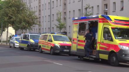 Vor einem Haus in Rathenow stehen Polizeiautos sowie Rettungswagen und das Auto eines Notarztes.