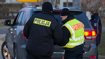 Polnische und deutsche Polizisten überprüfen in Biegen gemeinsam ein Auto.