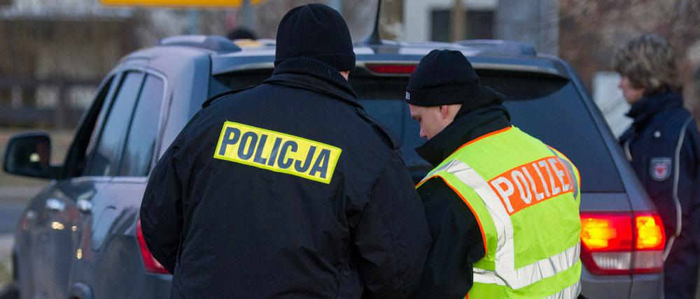 Polnische und deutsche Polizisten überprüfen in Biegen gemeinsam ein Auto.