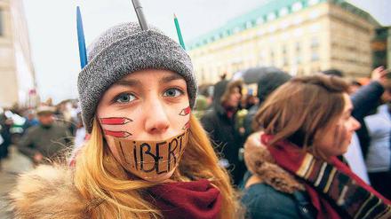 Meinungsfreiheit. Eine junge Frau zeigt am Pariser Platz ihre Sicht.