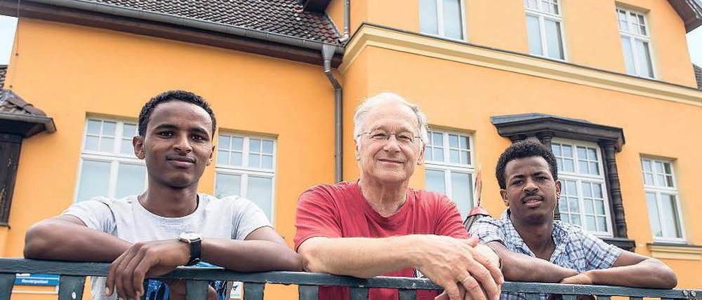 Martin Patzelt (M., CDU) und die beiden Flüchtlinge aus Eritrea Haben (l., 19) und Awet (r., 24) am Gemeindehaus in Briesen.