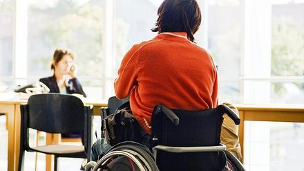 Behinderte Frau im Rollstuhl im Warteraum einer brandenburgischen Behörde.
