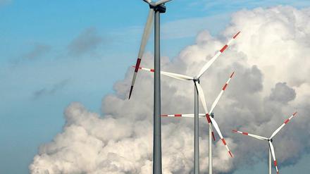 Alte und neue Kraft. Windräder drehen sich vor den Kühltürmen des Kraftwerks der Vattenfall Europe AG im brandenburgischen Jänschwalde.