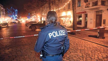 Im Dunkel. Am 1. Dezember 2017 sperrte eine Polizistin eine Straße in der Nähe des Weihnachtsmarkts in der Potsdamer Innenstadt ab, nachdem Bombenentschärfer ein verdächtiges Paket unschädlich gemacht hatten. Nach den Tätern wird fieberhaft gesucht.