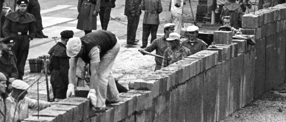 Baubeginn der Mauer: Unter der Aufsicht von bewaffneten Volkspolizisten errichtete 1961 eine Ostberliner Maurerkolonne an der sowjetisch-amerikanischen Sektorengenze am Potsdamer Platz in Berlin eine Mauer. 