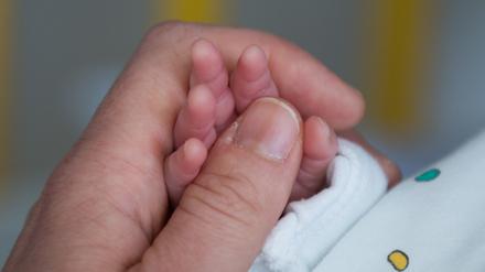 Eine Mutter hält in einem Krankenhaus die kleine Hand ihres Sohnes (Symbolbild).