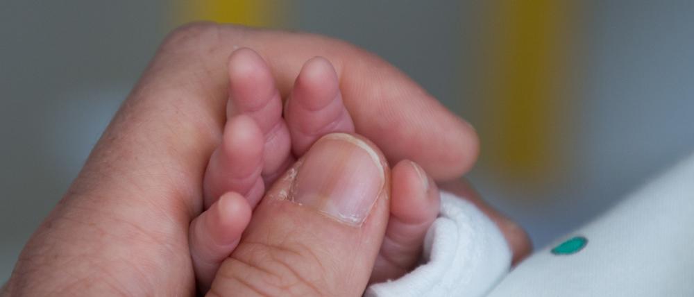 Eine Mutter hält in einem Krankenhaus die kleine Hand ihres Sohnes (Symbolbild).