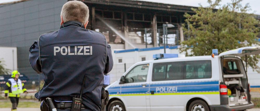 Ein Polizist am 25. August 2015 vor einer durch einen Anschlag zerstörten Asylunterkunft in Nauen.