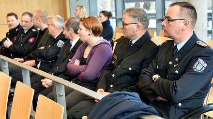 Feuerwehrleute warten im Amtsgericht Brandenburg/Havel auf den Prozessbeginn nach dem Tod von Feuerwehrmännern.