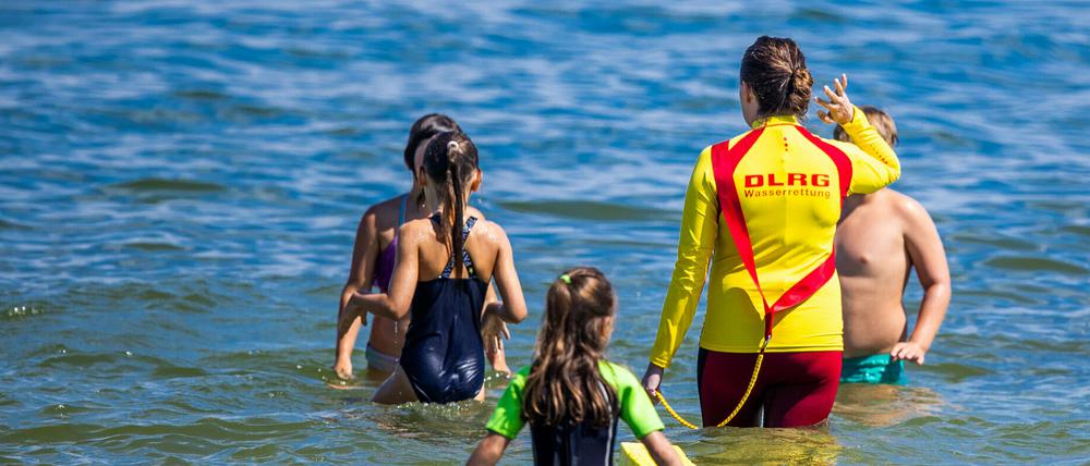 Eine Rettungsschwimmerin mit Kindern eines Schwimmkurses. Auch Erwachsene sollten ihre Fähigkeiten auffrischen (Archivbild).
