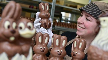 Angelina Piosik, Mitarbeiterin der Confiserie Felicitas GmbH, hält einen Schokoladen-Osterhasen in ihren Händen. 