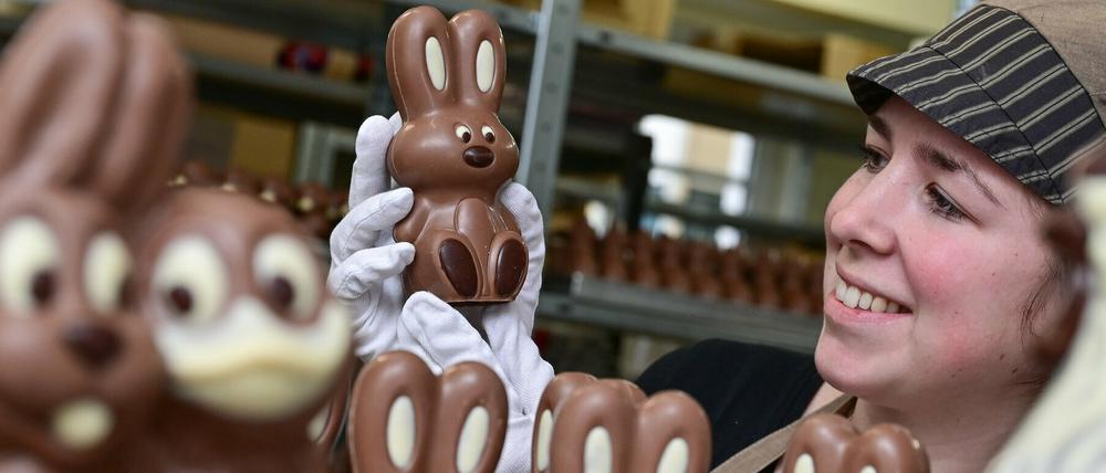 Angelina Piosik, Mitarbeiterin der Confiserie Felicitas GmbH, hält einen Schokoladen-Osterhasen in ihren Händen. 