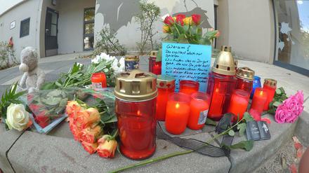 Vor einem Hochhaus im Märkischen Viertel in Berlin wurden Blumen und Kerzen abgelegt. Dort wurde ein acht Jahre alter Junge von einem Baumstumpf erschlagen.