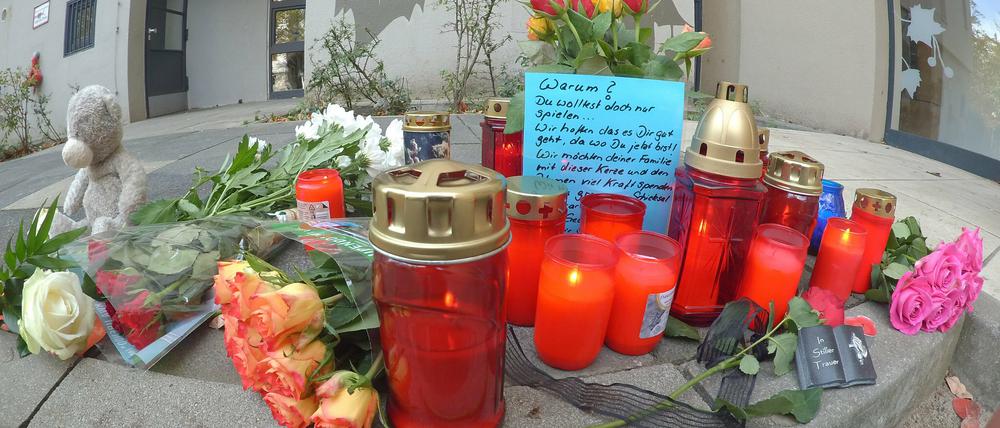 Vor einem Hochhaus im Märkischen Viertel in Berlin wurden Blumen und Kerzen abgelegt. Dort wurde ein acht Jahre alter Junge von einem Baumstumpf erschlagen.