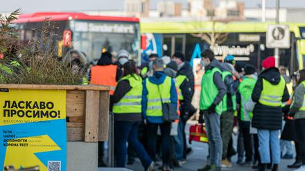 Helfer stehen auf dem Cottbuser Hauptbahnhof und erwarten Flüchtlinge aus der Ukraine. 