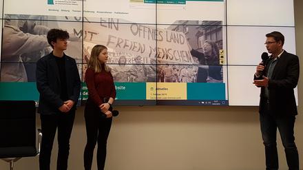 Maguns Müller und Alina Stutz mit ihrem Geschichtslehrer Steve Sachse bei der Vorstellung des Programms zu "30 Jahre Mauerfall" im Landtag.