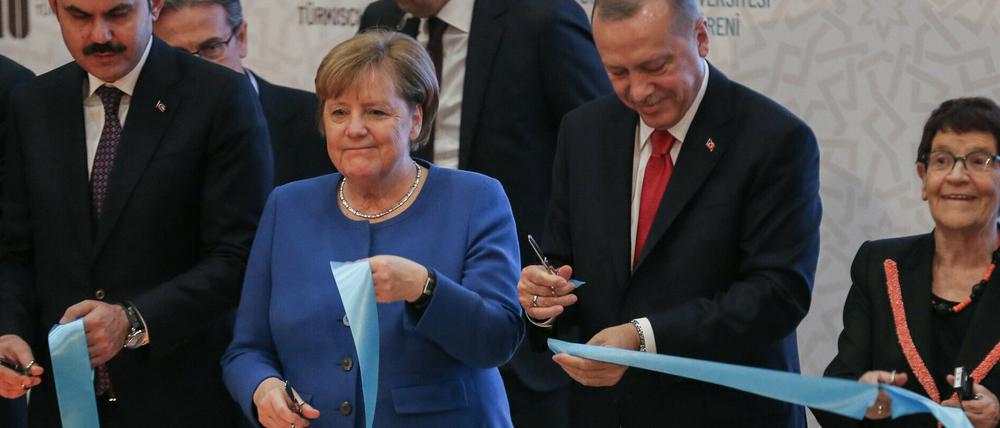 Bundeskanzlerin Angela Merkel (CDU, Mitte) und Recep Tayyip Erdogan (2.v.r), Präsident der Türkei, schneiden während der Eröffnungszeremonie der türkisch-deutschen Universität symbolisch ein Band durch.