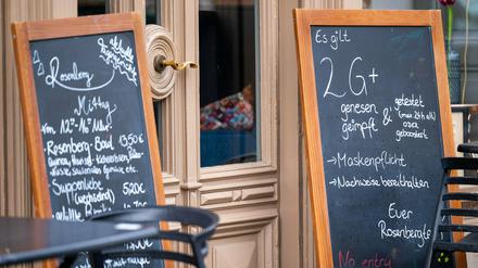 Ein Schild vor einem Café in der Potsdamer Innenstadt weißt die Besucher auf die geltende 2G+ Regel hin.