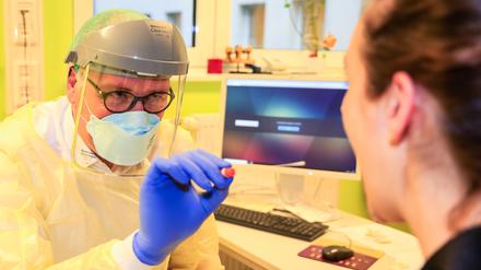 Tillmann Schumacher, Facharzt für Innere Medizin und Infektiologie beim Ernst von Bergmann-Klinikum, nimmt einen Abstrich, um eine Patientin auf das Coronavirus zu überprüfen.