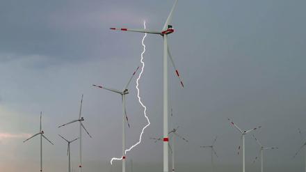 Ein Blitz leuchtet zwischen Windenergieanlagen im Windpark "Odervorland" im Landkreis Oder-Spree in Ostbrandenburg.