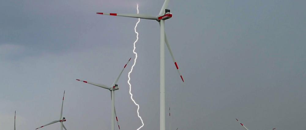 Ein Blitz leuchtet zwischen Windenergieanlagen im Windpark "Odervorland" im Landkreis Oder-Spree in Ostbrandenburg.