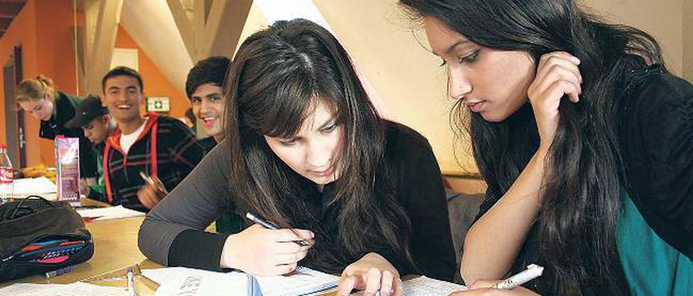 Bildungsferne Migranten? Von wegen! Die beiden Schülerinnen Saryeda (r.) und Farhat büffeln in der studentischen Hausaufgabenhilfe des Kuze. Die Studenten helfen bei englischen Aufsätzen oder höherer Mathematik.