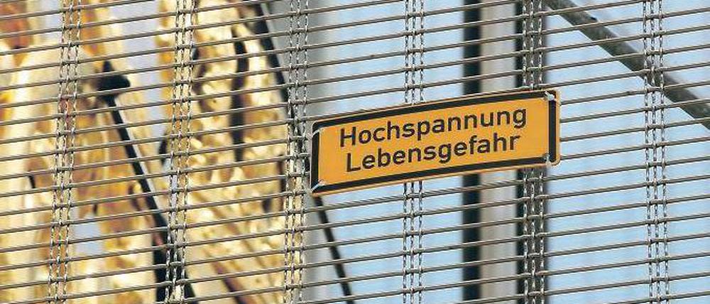 Gegner des Wiederaufbaus der Garnisonkirche haben vor Monaten dieses gelbe Warnschild an den Sicherheitskäfig für die Wetterfahne des montiert.