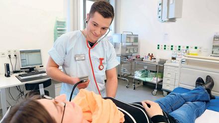 Nah dran. Krankenpflege-Azubi Justus Dreier im Einsatz im Potsdamer St. Josefs- Krankenhaus. Der 21-Jährige misst einer Patientin in der Notaufnahme den Blutdruck.