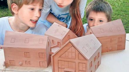 Neues Zuhause. Die Kinder bestaunen das Modell des geplanten Heimes.
