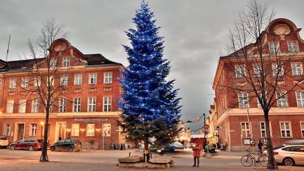 Am Bassinplatz mit dem blau erleuchteten Weihnachtsbaum beginnt der Weihnachtsmarkt in der Brandenburger Straße.