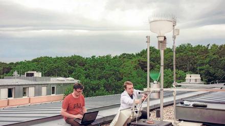 Komplexes Konstrukt. GFZ-Forscher Torsten Queisser (links) und Gunnar Pruß arbeiten an dem automatisierten Regenwassersammler.