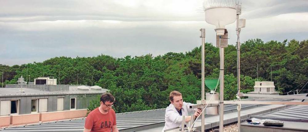 Komplexes Konstrukt. GFZ-Forscher Torsten Queisser (links) und Gunnar Pruß arbeiten an dem automatisierten Regenwassersammler.